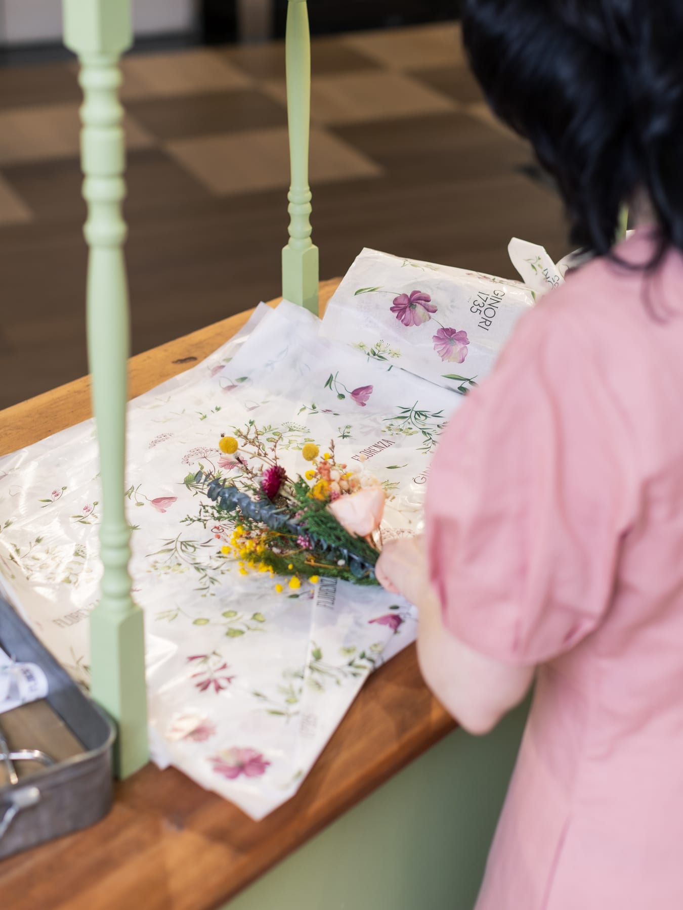 A florist wrapping a bouquet in Ginori 1735 branded tissue