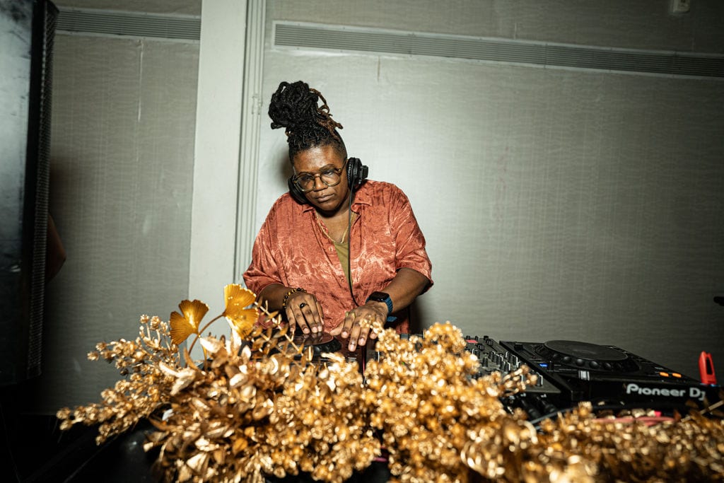 A DJ behind a gilded floral DJ booth