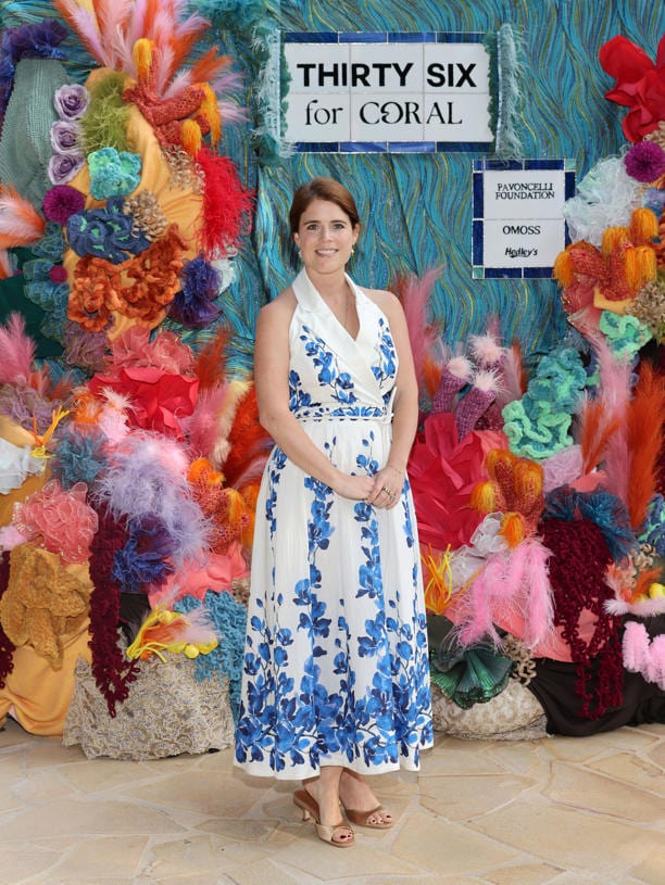 A guest in a floral dress at the Thirty Six for Coral wall