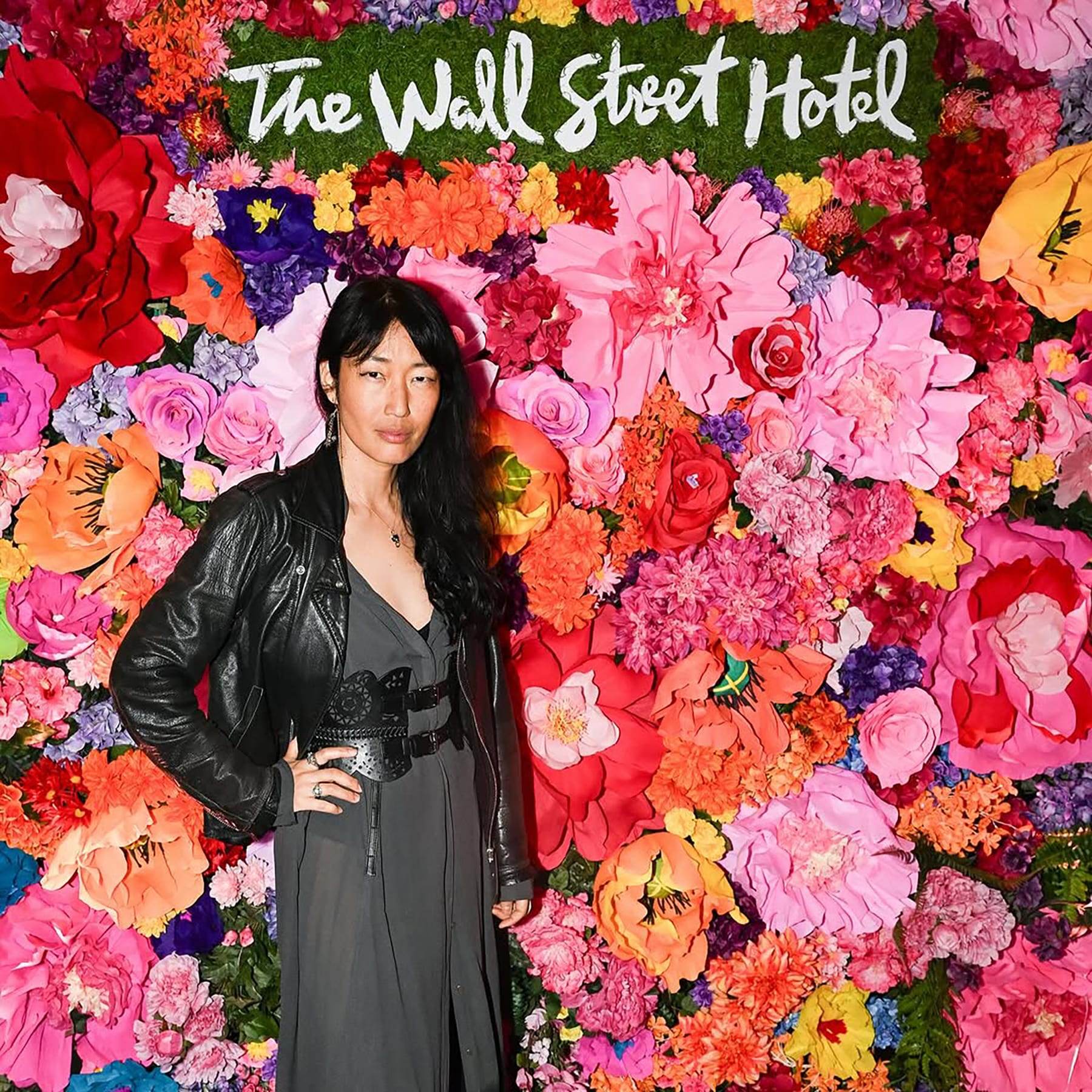 Four guests posing at the Wall Street Hotel flower wall