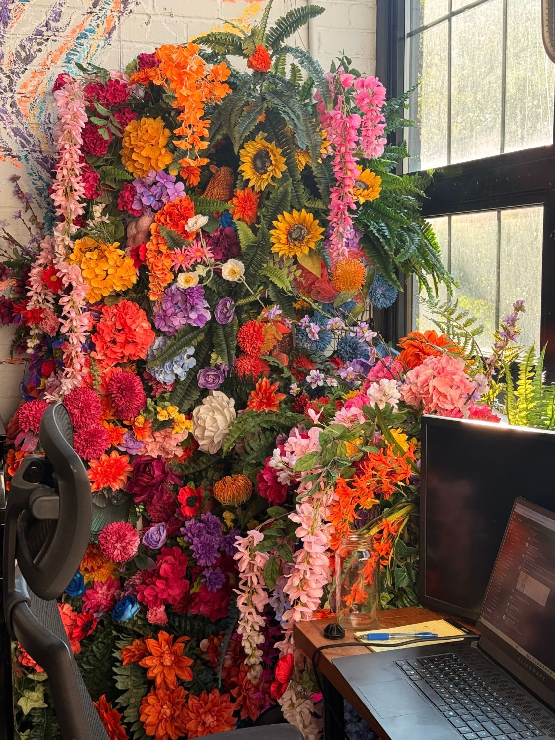 Floral installation blooming around a home workspace